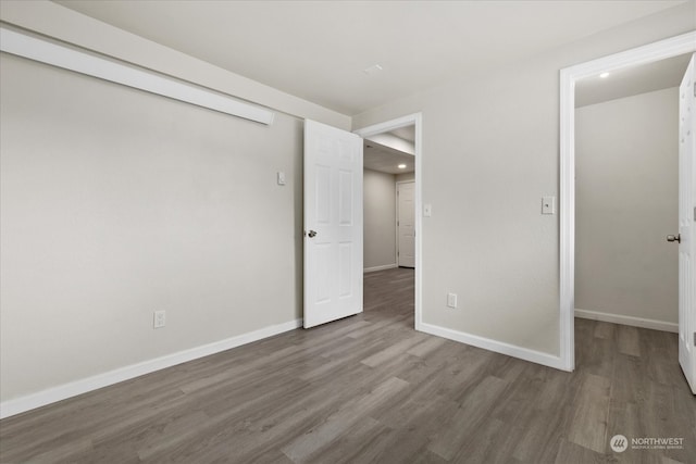 unfurnished bedroom with dark wood-type flooring and a closet