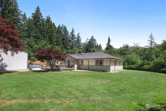 back of house with a deck and a yard