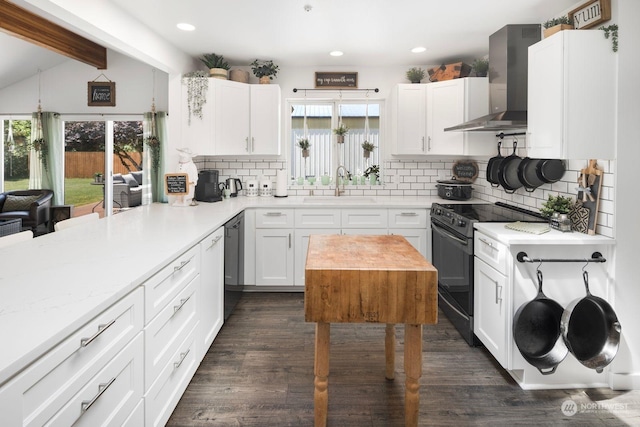 kitchen with range with electric cooktop, white cabinets, wall chimney exhaust hood, and backsplash