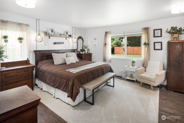 bedroom featuring multiple windows and dark hardwood / wood-style floors