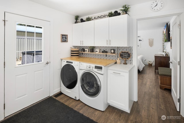 laundry room with dark wood-type flooring, cabinets, and washer and clothes dryer