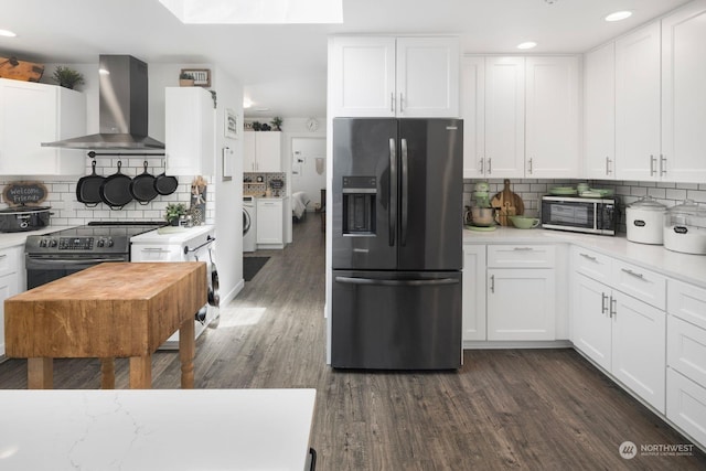 kitchen featuring appliances with stainless steel finishes, dark hardwood / wood-style floors, wall chimney exhaust hood, white cabinets, and tasteful backsplash