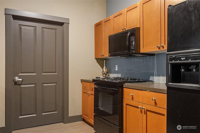 kitchen with light hardwood / wood-style flooring and black appliances