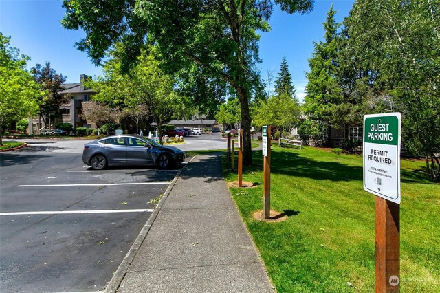 view of parking / parking lot featuring a yard