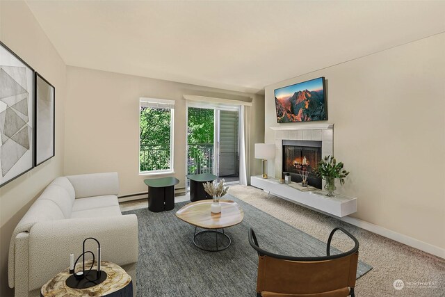 living room featuring baseboard heating, a fireplace, and carpet flooring