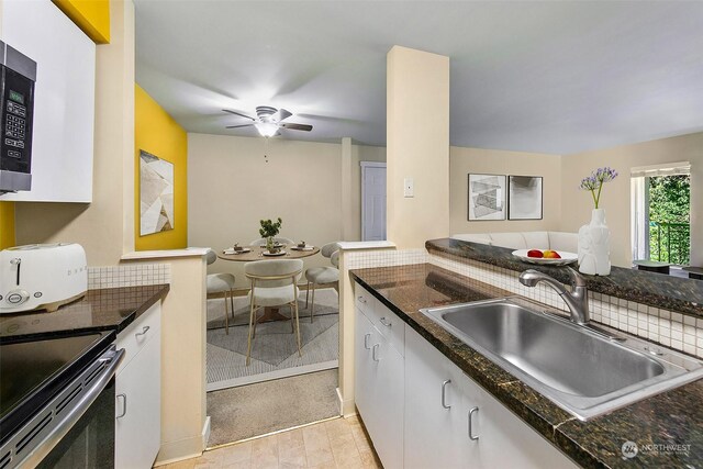 kitchen featuring light tile patterned floors, dark stone counters, ceiling fan, decorative backsplash, and sink