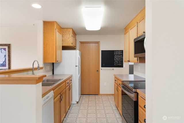 kitchen featuring light brown cabinetry, sink, appliances with stainless steel finishes, and light tile patterned floors