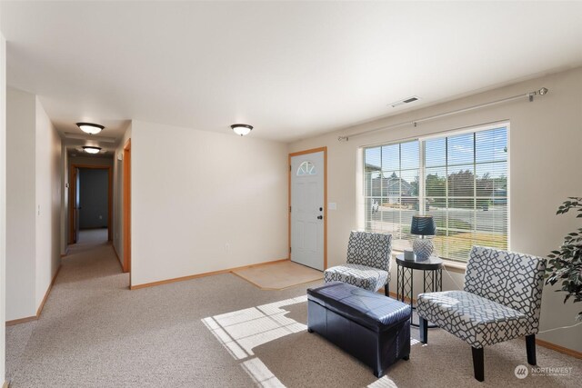 living area featuring light carpet