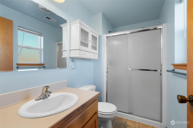 bathroom featuring an enclosed shower, vanity, tile patterned floors, and toilet