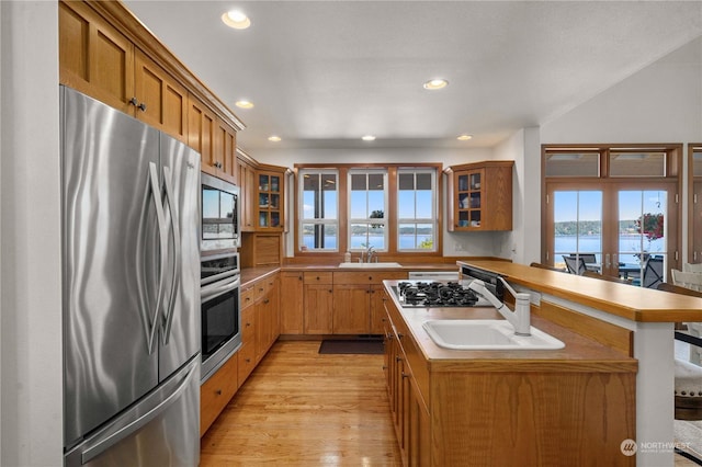 kitchen with a water view, appliances with stainless steel finishes, sink, and a wealth of natural light