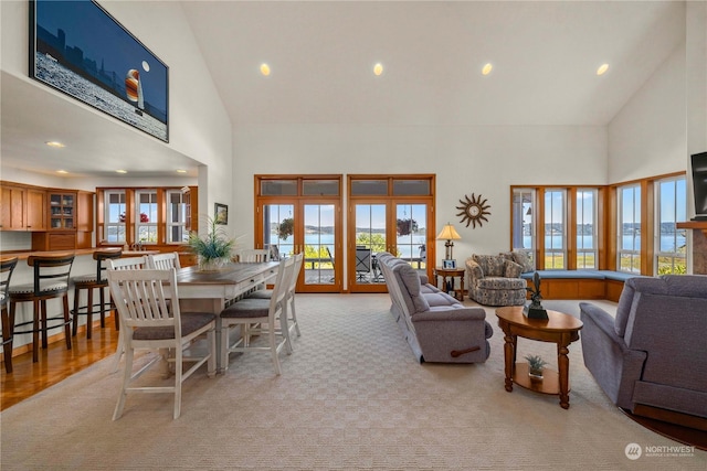 carpeted living room featuring french doors and high vaulted ceiling