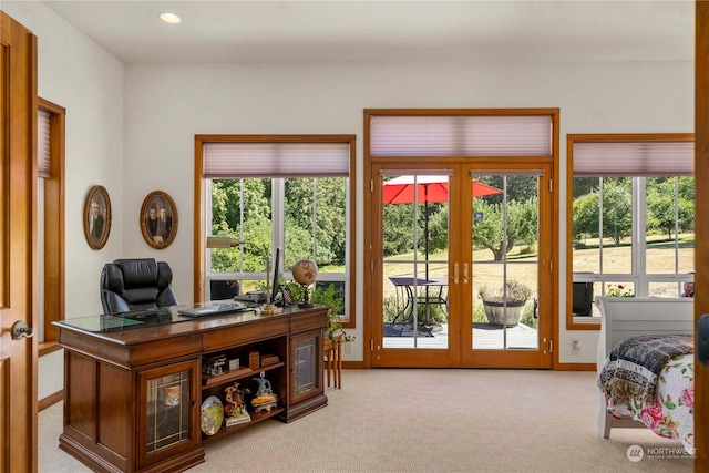 office featuring french doors, light colored carpet, and a healthy amount of sunlight