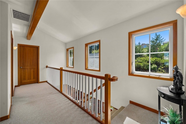 hall with vaulted ceiling with beams and light colored carpet