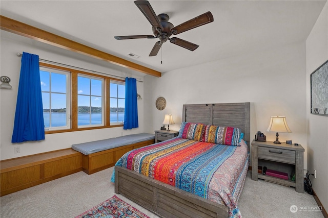 carpeted bedroom with ceiling fan, beamed ceiling, and a water view