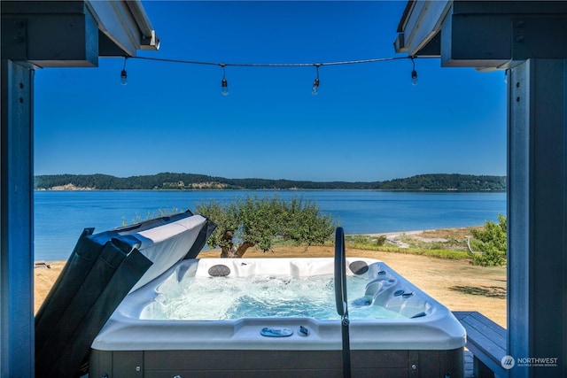 exterior space featuring a water view and a hot tub