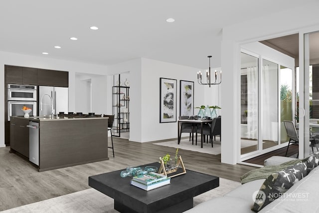 living room with a notable chandelier and light wood-type flooring