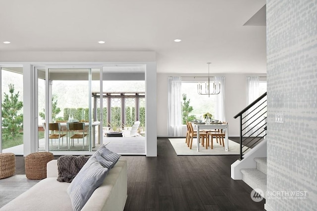 living room with dark wood-type flooring and a notable chandelier