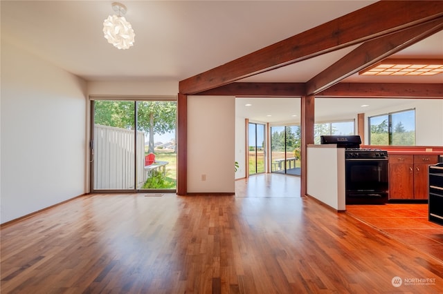 interior space with beam ceiling and hardwood / wood-style floors