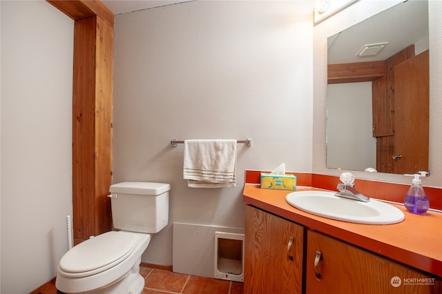 bathroom featuring tile patterned flooring, vanity, and toilet