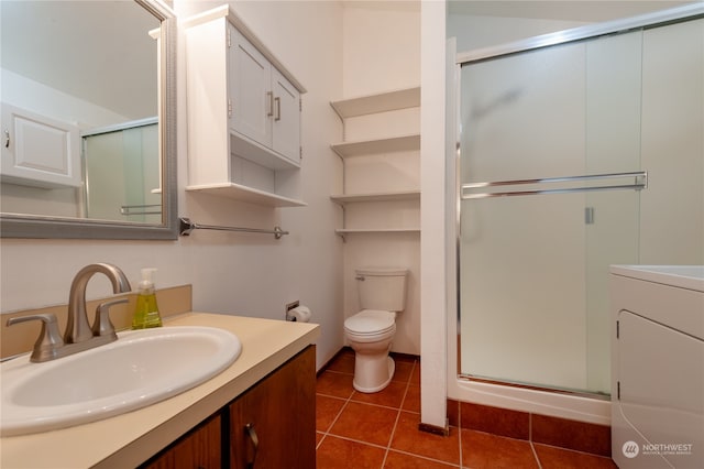 bathroom with tile patterned floors, a shower with shower door, vanity, and toilet