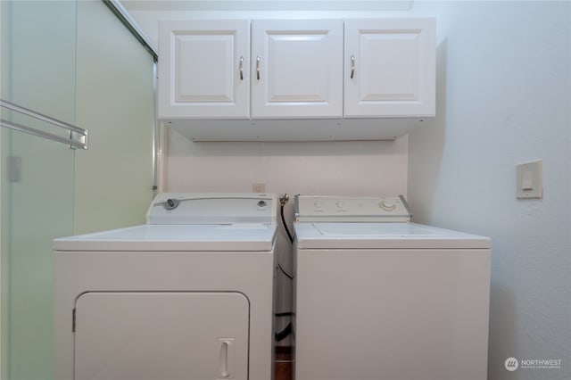 clothes washing area with independent washer and dryer and cabinets