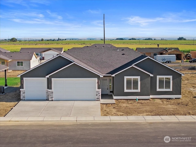 view of front facade featuring a rural view and a garage