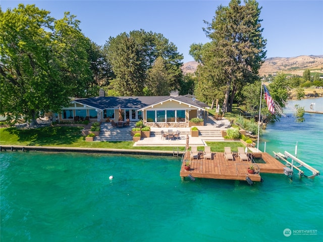 back of house featuring a water view and a patio area