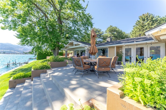 view of patio with a water and mountain view and french doors