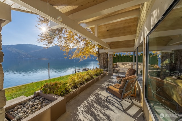 view of patio featuring a water and mountain view