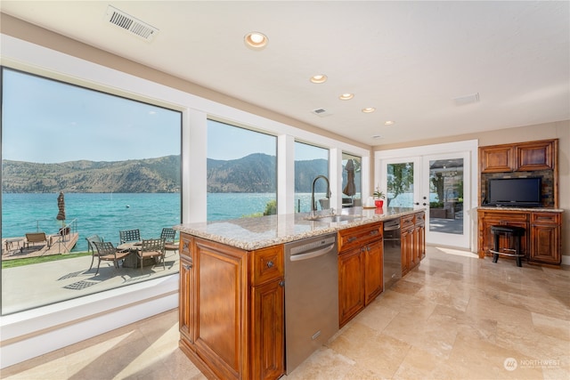 kitchen with french doors, light tile patterned floors, stainless steel dishwasher, an island with sink, and light stone countertops