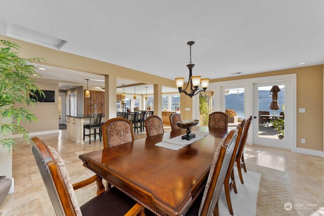 tiled dining room featuring an inviting chandelier