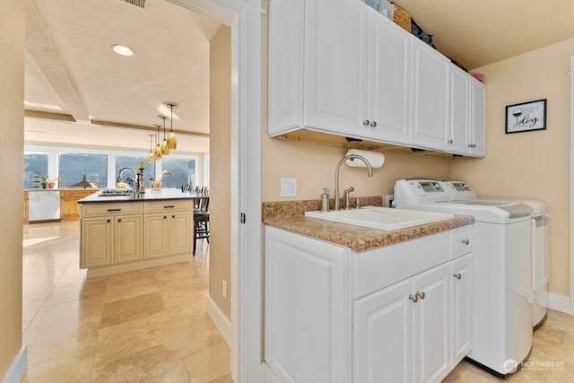 washroom featuring cabinets, washing machine and dryer, sink, and light tile patterned floors