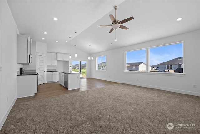 unfurnished living room featuring ceiling fan, sink, dark wood-type flooring, and vaulted ceiling