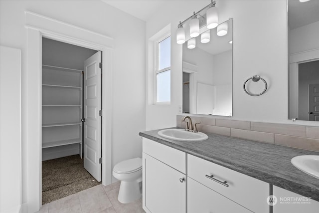 bathroom featuring tile patterned flooring, vanity, and toilet