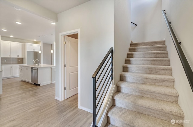 stairway featuring sink and hardwood / wood-style floors