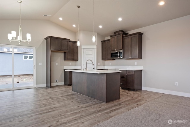 kitchen featuring dark brown cabinets, light hardwood / wood-style flooring, hanging light fixtures, and a chandelier