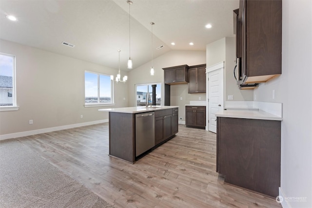 kitchen featuring a kitchen island with sink, sink, decorative light fixtures, light hardwood / wood-style floors, and stainless steel appliances