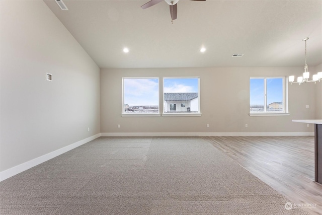 unfurnished room with ceiling fan with notable chandelier