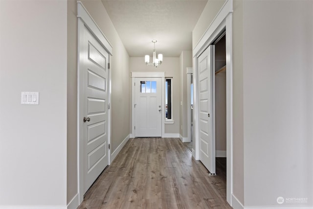 doorway featuring light hardwood / wood-style floors and a notable chandelier