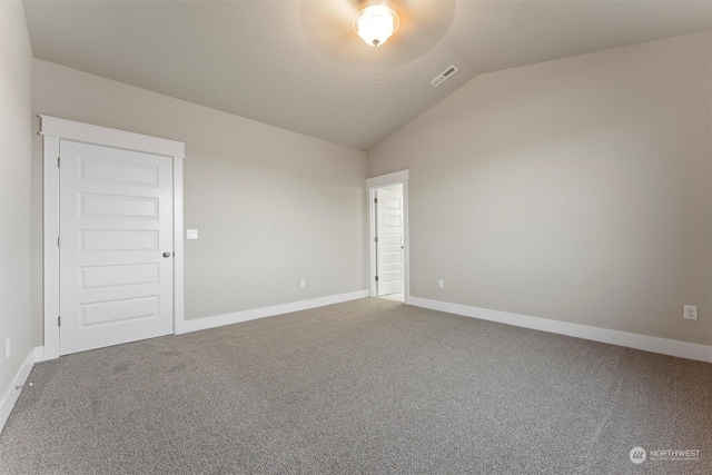 carpeted spare room featuring ceiling fan and vaulted ceiling