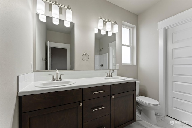 bathroom featuring a shower, vanity, and toilet