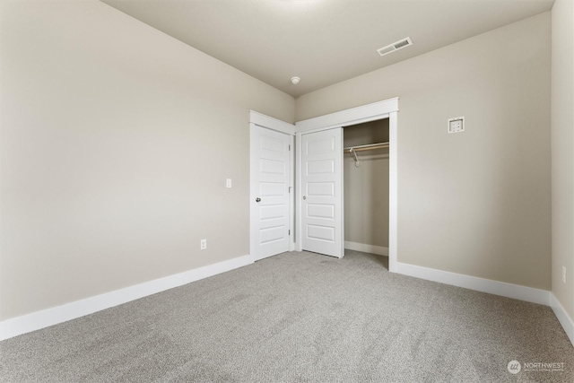 unfurnished bedroom featuring carpet and a closet