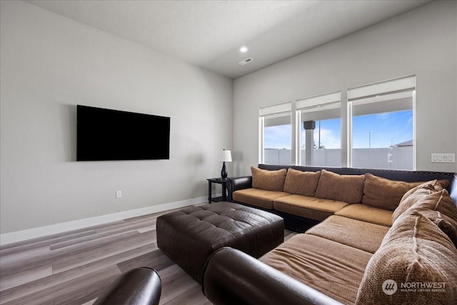 living area with recessed lighting, visible vents, baseboards, and wood finished floors