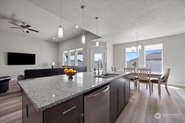 kitchen with a sink, light wood-style floors, a textured ceiling, and dishwasher