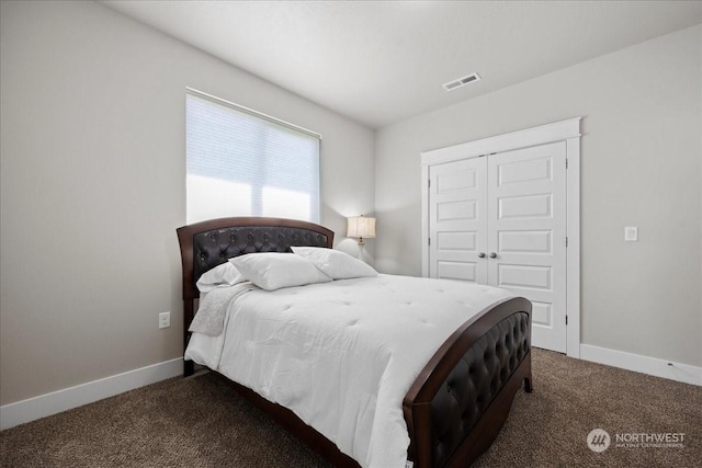 bedroom featuring baseboards, visible vents, dark carpet, and a closet