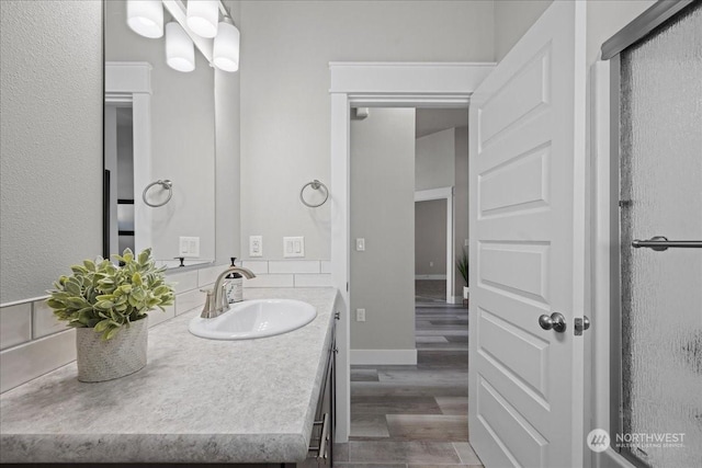 bathroom featuring vanity, baseboards, and wood finished floors