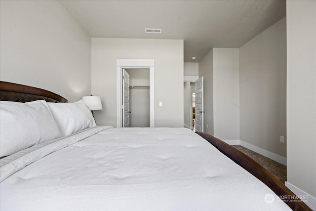 bedroom featuring baseboards, visible vents, a walk in closet, and a closet