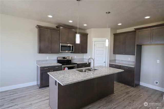 kitchen with appliances with stainless steel finishes, baseboards, a sink, and dark brown cabinetry