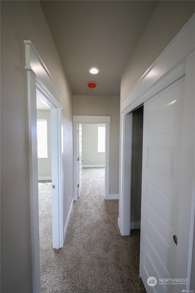 corridor featuring carpet flooring and baseboards