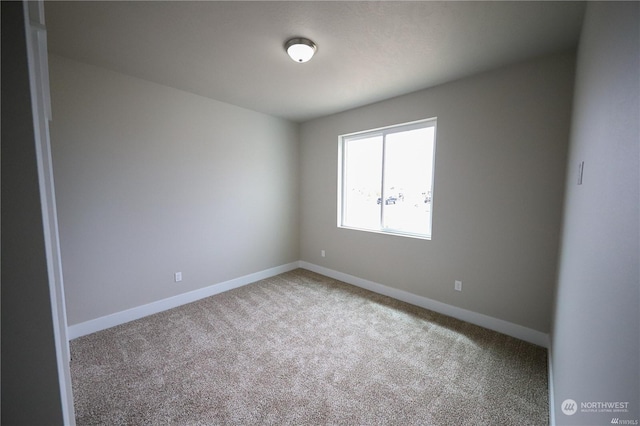 empty room with carpet and baseboards